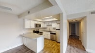 This single-floor residence offers a thoughtfully designed layout that balances comfort and functionality. The open-concept kitchen is a standout feature, outfitted with stainless steel appliances including an electric range, built-in microwave, dishwasher, and refrigerator. Crisp white cabinetry with modern hardware lines the walls, complemented by light quartz-style countertops and a peninsula that provides additional prep space and a natural transition into the adjoining living and dining areas. Wood-style flooring runs throughout the kitchen and main living spaces, adding warmth and durability.

The living area is generously sized, featuring neutral toned walls, a ceiling fan, and direct access to a private balcony through a sliding glass door that invites natural light into the room. The bedrooms are carpeted and finished with textured ceilings and neutral walls, offering quiet and comfortable retreats. One bedroom features a window with blinds that allows for natural light while maintaining privacy.

The bathrooms are cleanly finished with wood-look flooring, white cabinetry, quartz-style countertops, and tub-shower combinations with tile surrounds and brushed nickel fixtures. Throughout the space, a consistent neutral color palette and clean finishes create a cohesive, move-in ready environment.
