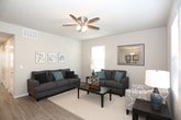 This single-floor residence offers a thoughtfully designed layout with multiple bedrooms, two full bathrooms, a comfortable living area, and a functional kitchen. The living room is bright and welcoming, featuring ceiling fans, durable wood-look flooring, and multiple windows fitted with blinds that allow for natural light control. Ample space accommodates generous seating arrangements, making it ideal for relaxing or entertaining.

The kitchen is designed for efficiency, featuring a galley-style layout with dark cabinetry, light countertops, and a full suite of stainless steel appliances including a refrigerator, range, and over-the-range microwave. Light wood-look flooring adds warmth to the functional space.

The bedrooms are carpeted and well-sized, each equipped with ceiling fans and windows that bring in natural light. The primary bedroom offers additional space for a dresser and features easy access to the hallway. Secondary bedrooms are versatile and suitable for a variety of uses.

Both bathrooms are finished with dark wood cabinetry, neutral countertops, and large mirrors. One bathroom includes a shower-tub combination, while the other features a shower with a curtain. Wood-look flooring ties the bathrooms together with a clean, cohesive aesthetic throughout the home.