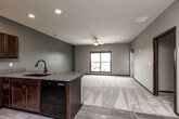 Located at 2861 Prairie Hill Dr in Marion, Iowa, this one-bedroom, one-bathroom unit offers a thoughtfully designed single-floor layout. The open-concept living area seamlessly combines the kitchen, dining, and living spaces into one cohesive, light-filled zone. The kitchen is well-appointed with rich, warm-toned cabinetry, granite countertops, black appliances including a refrigerator, range, and microwave, and a peninsula with an undermount sink — ideal for both meal prep and casual dining. Tile flooring runs throughout the kitchen and entry areas, transitioning to plush carpet in the living and bedroom spaces. The living area is bathed in natural light through a large picture window with outdoor views, and is complemented by a ceiling fan overhead. The bedroom is a comfortable retreat, featuring carpet flooring, a ceiling fan, and a generously sized window that frames pleasant outdoor scenery. Two closets provide ample storage throughout the unit. The bathroom features neutral tile flooring and clean, modern finishes. A dedicated laundry area and a hallway complete the functional layout, making this a well-rounded and practical living space.