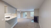 This single-floor residence offers a thoughtfully designed layout that balances comfort and functionality. The open-concept living and dining area is carpeted and bathed in natural light, courtesy of a sliding glass door that opens to a private balcony overlooking lush greenery. A ceiling fan adds a casual charm to the space. A sleek, tile-surround fireplace with a dark finish serves as a refined focal point in the living area, complemented by an adjacent window fitted with horizontal blinds.

The kitchen is both stylish and practical, featuring white cabinetry, light quartz countertops, a stainless steel dishwasher, and wood-look flooring that creates a clean contrast to the surrounding carpeted areas. A pass-through counter connects the kitchen to the living space, enhancing the open flow of the layout.

The bedroom is a calm, neutral retreat with plush carpeting, soft walls, and a sliding-door closet offering built-in storage. The full bathroom is finished with white cabinetry, a quartz vanity top, a combination tub and shower, and wood-look flooring — all accented with brushed nickel fixtures for a cohesive, modern aesthetic. Throughout the space, neutral tones and clean finishes create a bright, inviting atmosphere.