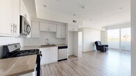 Located at 744 Hartford Ave in Los Angeles, this two-bedroom, two-bathroom residence offers a clean, modern aesthetic throughout. Light wood-style flooring flows seamlessly across the entire floor plan, complementing the crisp white walls and creating a bright, cohesive feel.

The open-concept kitchen and living area serves as the heart of the home. The kitchen is well-appointed with white shaker cabinetry, subway tile backsplash, taupe countertops, and a full suite of stainless steel appliances including a gas range, built-in microwave, and dishwasher. A hallway entry leads naturally into this shared living space, enhancing the sense of openness.

The primary bedroom is generously sized, featuring sliding mirrored closet doors and direct access to a private balcony through glass French doors, offering views of iconic Los Angeles palm trees. The second bedroom is bright and airy, with a large window framing outdoor views and ample room for furnishings.

Both bathrooms are finished with wood-toned vanities, large mirrors, and combination shower-tub enclosures. Each bedroom is served by a dedicated closet, with two hallways providing practical circulation throughout the unit. The space strikes a balance between functional design and modern comfort in a prime Los Angeles location.