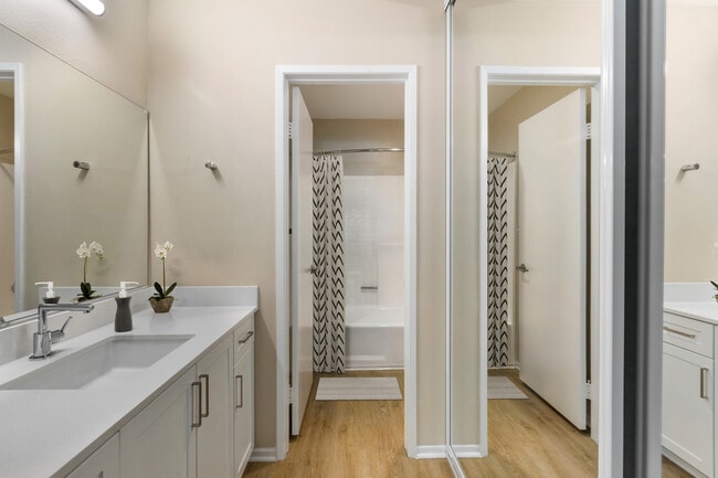 Baño renovado del paquete II con encimeras de cuarzo blanco, gabinetes blancos y pisos de superficie dura. - Avalon Burbank