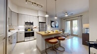 Located at 3218 Gonzales St in Austin's vibrant 78702 neighborhood, this thoughtfully designed one-bedroom, one-bathroom residence offers a contemporary living experience within a compact, efficient footprint. The open-concept main area seamlessly integrates the kitchen, dining, and living room, creating a welcoming and versatile space. The kitchen is well-appointed with stainless steel appliances including a range, over-the-range microwave, and refrigerator, complemented by light wood-grain cabinetry, subway tile backsplash, and a butcher block-topped island with seating for two. Track and pendant lighting add a modern flair overhead, while polished concrete-style flooring ties the space together. The living area benefits from large windows and glass door access to the outdoors, allowing ample natural light to fill the room. A ceiling fan adds comfort to the space. The bedroom offers a cozy retreat with a window for natural light and two closets for generous storage. The full bathroom features a soaking tub and shower combination, wood-tone vanity cabinetry, white countertops, and recessed lighting. Additional highlights include a dedicated pantry, in-unit laundry, and a clean, neutral palette throughout that lends a bright and modern ambiance to every corner of the home.