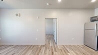 Located at 609 Lupo Lane in Douglas, Georgia, this single-story, one-bedroom, one-bathroom unit offers a thoughtfully designed layout with modern finishes throughout. Light wood-style laminate flooring runs continuously across the entire space, creating a clean, cohesive look.

The open-concept living, dining, and kitchen area serves as the heart of the unit. The kitchen is well-equipped with rich gray shaker-style cabinetry, granite-look countertops, a stainless steel refrigerator, range, and microwave, along with recessed lighting overhead — providing both style and functionality. The adjoining living and dining area is bright and open, with a ceiling fan adding comfort and airflow.

The bedroom is a comfortable size, featuring a ceiling fan with light fixture, a wall-mounted mini-split HVAC unit for individual climate control, and a large window that allows natural light to fill the room with views of the surrounding greenery. A dedicated closet provides convenient storage.

The bathroom is clean and functional, featuring a full soaking tub and shower combination with built-in shelving, complemented by granite-look countertops consistent with the rest of the unit.

Throughout the space, neutral wall tones, white trim, and consistent flooring contribute to a fresh, move-in-ready atmosphere that is both practical and inviting.