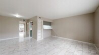 Located at 5605 Chimney Rock Rd in Houston, TX, this one-bedroom, one-bathroom unit offers a thoughtfully organized single-floor layout with a clean, neutral aesthetic throughout. Marble-look porcelain tile flooring extends seamlessly across every room, lending a bright and polished feel to the entire space.

The open living and dining area provides a comfortable gathering space, highlighted by a built-in shelving unit and a kitchen pass-through window framed by a white brick-style surround — a distinctive architectural detail that adds character while maintaining an open connection between rooms. The kitchen features white appliances and ample counter space visible through the pass-through.

The bedroom is a well-proportioned private retreat, complete with a large sliding glass door fitted with vertical blinds that allow natural light to filter in. Two closets provide generous storage, and the room connects conveniently to the rest of the unit. The bathroom is finished with classic white subway tile surrounding a full bathtub and shower combination.

Throughout the unit, warm beige walls complement the light flooring, and textured ceilings add a subtle layer of dimension. Central HVAC with ceiling vents ensures year-round comfort. The overall ambiance is clean, functional, and move-in ready.