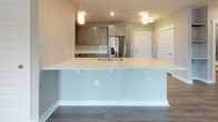 Located at 50 Central Island St on Daniel Island, SC, this single-floor residence offers a thoughtfully designed open-concept layout with a neutral color palette and quality finishes throughout. The kitchen serves as a central gathering point, showcasing grey shaker-style cabinetry, white quartz countertops, a classic subway tile backsplash, and a full suite of stainless steel appliances including a range, over-the-range microwave, and refrigerator. A spacious island with an integrated sink and pendant lighting above anchors the space and provides additional prep and seating areas. Hardwood-style luxury vinyl plank flooring flows through the main living areas, adding warmth and continuity. The bedrooms are carpeted for comfort and each features a ceiling fan and natural light from windows with blinds. Both bathrooms are finished with granite-topped vanities, white cabinetry, tile-surround tub and shower combinations, and matching hardwood-style flooring. Generous walk-in closets with wire shelving systems are accessible from the bedrooms, offering ample storage. The overall design is clean, modern, and move-in ready, making this Daniel Island residence a well-rounded and functional living space.