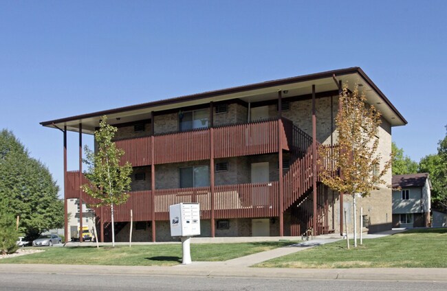 Encantador edificio de apartamentos de tres pisos con exterior de ladrillo y detalles de madera, ubicado en un exuberante entorno verde. - 591 West Prentice Avenue