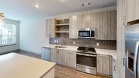 This contemporary 660 square foot apartment in Herndon, VA, offers a perfect blend of style and functionality. The heart of the home is a stunning kitchen, showcasing light wood cabinetry, stainless steel appliances, and a contrasting brown subway tile backsplash. The kitchen opens to a bright living area, creating an ideal space for entertaining or relaxing.

The apartment boasts hardwood floors throughout, adding warmth and elegance to the space. The bedroom, measuring 140 square feet, provides ample room and features a large window that floods the space with natural light. The bathroom is designed with modern aesthetics in mind, featuring clean lines, white subway tiles, and contemporary fixtures.

A standout feature is the open-concept layout, which maximizes the use of space and creates a flowing, airy atmosphere. The apartment also offers city views, visible through well-placed windows that add to the overall ambiance.

Recessed lighting and pendant lights in the kitchen contribute to the modern feel, while providing both task and ambient lighting. The neutral color palette used throughout allows for easy personalization, making this apartment a perfect canvas for various design styles.

Despite its compact size, clever design elements ensure that every square foot is utilized efficiently, resulting in a space that feels much larger than its actual dimensions. This apartment is an excellent example of how contemporary design can create a stylish and functional living space in an urban setting.