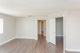 Located at 150 Drake St in Pomona, California, this single-story residence offers a well-organized layout with thoughtfully updated interiors throughout. The living area is bright and open, featuring light hardwood-style flooring, neutral gray walls, and a textured ceiling. A ceiling fan and a window allowing natural light contribute to the comfortable ambiance of this space, which flows seamlessly toward the kitchen.

The kitchen is a standout feature, outfitted with white shaker-style cabinetry, granite-look countertops, and a full suite of stainless steel appliances including a refrigerator, gas range, microwave, and dishwasher. A tray ceiling detail adds architectural character to this functional space.

The bedrooms are carpeted for comfort and finished in soft gray tones. One bedroom notably features a walk-in closet with built-in shelving, as well as direct access to an adjacent area with additional white cabinetry. Windows in the bedrooms admit natural light, enhancing the clean, airy feel.

The bathroom is neatly appointed with a white vanity, granite-look countertop, a large mirror with vanity lighting, and hardwood-style flooring. Clean white finishes and neutral tones are consistent throughout, giving the entire space a cohesive, move-in-ready aesthetic.