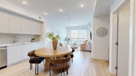 Located at 3271 Hilltown Drive in Kelowna, BC, this well-appointed 2-bedroom, 2-bathroom unit offers a thoughtfully designed open-concept layout finished with light wood flooring and a bright, neutral palette throughout. The combined kitchen and living area serves as the heart of the home, where a modern kitchen features sleek flat-panel cabinetry, stainless steel appliances, a tiled backsplash, and recessed lighting above light hardwood floors. The living room is bathed in natural light from a large sliding glass door that opens onto a private balcony, revealing sweeping views of the surrounding mountains and lake — a defining feature of this space. A wall-mounted mini-split unit provides year-round climate control. The primary bedroom enjoys generous proportions, large windows framing the scenic lake and mountain backdrop, and direct access to a dedicated closet. The second bedroom also includes a closet and is finished in the same clean, modern style. Two well-designed bathrooms serve the unit: one with a glass-enclosed walk-in shower and modern vanity, the other with a full soaker tub and tiled surround. An in-unit laundry area houses a stacked washer and dryer for added convenience. The balcony offers expansive views of the hillside community and Okanagan Lake, completing this refined Kelowna residence.