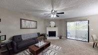 This single-floor residence offers a thoughtfully designed layout that balances comfort and functionality throughout its well-defined living spaces. The living room serves as the heart of the home, featuring plush carpeting, a textured ceiling with a ceiling fan, and a white brick fireplace as a focal point. A sliding glass door provides direct access to an outdoor patio, allowing natural light to filter into the space. The room comfortably accommodates a seating area and additional furnishings.

The kitchen is equipped with rich, dark espresso cabinetry paired with granite-style countertops and light wood-look flooring. It includes a full suite of white appliances — a refrigerator, range, and dishwasher — along with a breakfast bar that connects to the adjacent dining area, making it practical for everyday use and entertaining.

The bedroom is generously sized with soft carpeting, neutral walls, and a walk-in closet, offering a calm and restful atmosphere. The bathroom features matching dark cabinetry, a granite-style vanity countertop, and wood-look flooring consistent with the kitchen's design.

A dedicated in-unit laundry area houses a full-sized washer and dryer, adding everyday convenience to this well-rounded residence.