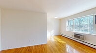 Located at 7 South Lake Drive in Hackensack, NJ, this one-bedroom, one-bathroom residence offers a bright and efficiently organized layout across a single floor. Polished hardwood floors run throughout the unit, reflecting natural light and lending warmth to every room.

The open-plan kitchen and living area forms the heart of the home, offering a versatile space for both everyday living and entertaining. Large windows invite generous amounts of natural light, creating an airy, welcoming atmosphere. Baseboard heating and a wall-mounted air conditioning unit ensure year-round comfort.

The bedroom is a well-proportioned private retreat, featuring a sliding-door closet and a window with an outdoor view. With four closets spread throughout the residence, storage is plentiful and practical.

The bathroom is clean and classic in design, showcasing white subway tile surrounding a full soaking tub with an overhead shower. A wood-toned vanity with under-sink cabinetry adds warmth, while a window above the tub provides natural ventilation and light.

Throughout the residence, crisp white walls and gleaming hardwood floors create a cohesive, bright aesthetic. The thoughtful layout maximizes every square foot, making this a comfortable and functional home in Hackensack, NJ.