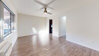 Located at 1801 W Garvey Ave in Alhambra, CA, this one-bedroom, one-bathroom unit offers a well-organized and efficiently designed single-floor layout. Wood-look flooring runs throughout the entire space, lending a cohesive and clean aesthetic to every room. Ceiling fans are present in multiple rooms, contributing to comfortable year-round living.

The bright living room is a welcoming focal point, featuring a fireplace with a wood mantel and ample natural light. It flows naturally into the dining area, creating an open and functional common space. The kitchen is well-appointed with rich dark cabinetry, white countertops, a mosaic tile backsplash, stainless steel gas range, and recessed lighting. A pantry provides additional storage, and a sliding glass door leads directly from the kitchen area to a private patio with outdoor views.

The bedroom offers a comfortable retreat, complete with a ceiling fan, wall-unit HVAC, a window for natural light, and a mirrored sliding-door closet. The bathroom is clean and functional, featuring a full bathtub and shower combination with a curved curtain rod, a white vanity, and overhead cabinetry for storage. A hallway connects the rooms with ease, completing this practical and well-designed unit.