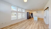 Located at 234 E Main St in Plainfield, Indiana, this well-appointed one-bedroom, one-bathroom unit offers a thoughtfully designed layout that maximizes comfort and functionality. The open-concept living and kitchen area serves as the heart of the home, featuring light wood-look flooring throughout and an expansive bank of windows that flood the space with natural light. A striking wall of stacked windows reaches toward the ceiling, enhancing the sense of openness and airiness.

The kitchen is a standout feature, equipped with rich dark-espresso cabinetry, a classic white subway tile backsplash, granite countertops, and a full suite of stainless steel appliances including a refrigerator, electric range, and microwave. A central kitchen island with a granite surface and built-in sink provides additional prep space and is finished with stylish pendant lighting overhead.

The bedroom offers a comfortable, carpeted retreat with large windows allowing ample natural light and outdoor views. A dedicated closet provides convenient storage. The bathroom is clean and modern, featuring a tiled walk-in shower with a sliding glass door, a granite-topped vanity with dark wood cabinetry, and wood-look tile flooring. Recessed lighting and crisp white walls throughout contribute to a bright, contemporary ambiance.
