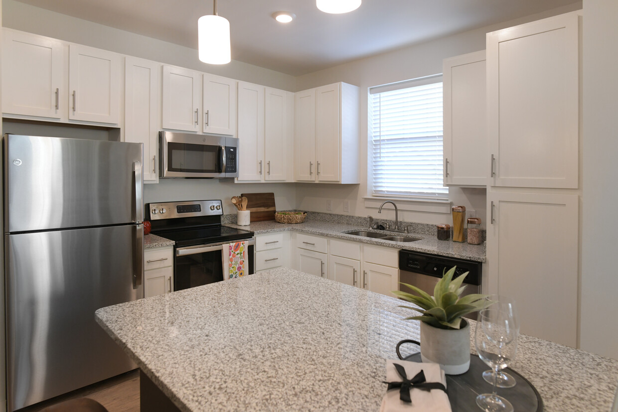 Cocina gourmet con encimeras de granito, gabinetes de estilo Shaker blancos & Electrodomésticos de acero inoxidable - Cottages at Cades Cove