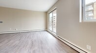 Located at 825 Trillium Park in Sarnia, Ontario, this well-appointed two-bedroom unit offers a comfortable and functional layout across a single floor. Light-toned vinyl plank flooring runs consistently throughout the space, creating a clean, cohesive look.

The open-concept living area is bright and welcoming, anchored by a large sliding glass door that opens onto a private balcony with outdoor views. Baseboard heating lines the perimeter, ensuring year-round comfort.

The kitchen is efficiently designed in a galley style, featuring white shaker cabinetry, dark granite-look countertops, a white subway tile backsplash, and stainless steel appliances including a refrigerator and range. A peninsula with an extended countertop provides a natural transition into the living space and offers additional workspace or casual seating.

Both bedrooms are well-proportioned with neutral warm-beige walls and large windows that bring in natural light. The primary bedroom offers a comfortable footprint, while the second bedroom provides flexibility for various uses.

The bathroom is finished with full-height tile surround in a neutral taupe tone, a white vanity with under-cabinet storage, and a shower-tub combination. Recessed lighting adds a polished touch throughout the unit.