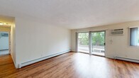 Located at 10233 W 34th St in Minnetonka, MN, this two-bedroom, one-bathroom unit offers a well-organized single-floor layout designed for comfortable everyday living. The open living room is a bright and airy space featuring warm hardwood-style flooring, baseboard heating, a wall-mounted air conditioning unit, and a sliding glass door that leads to a private balcony with outdoor views and abundant natural light. The kitchen is thoughtfully updated with white shaker-style cabinetry, granite countertops, a mosaic tile backsplash, stainless steel appliances, and matching hardwood-style flooring that flows seamlessly from the living area. The primary bedroom is generously proportioned, carpeted for comfort, and features a large window that brings in natural light, along with baseboard heating and a wall AC unit. The second bedroom also features plush carpet, a bright window, and a sliding double-door closet for convenient storage. The bathroom is finished with large-format subway tile surrounding the soaking tub and shower, paired with brushed nickel fixtures for a clean, modern aesthetic. Throughout the unit, neutral tones and clean lines create a calm, cohesive ambiance suited for a variety of lifestyles.