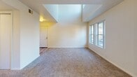 Located at 2505 5th St in Davis, CA, this two-story, 3-bedroom, 4-bathroom home offers a thoughtfully designed layout spread across two floors. The main level features a combined living and dining area with striking soaring ceilings, high clerestory windows that flood the space with natural light, and soft carpeting throughout. Sliding glass doors open to a private balcony, extending the living space outdoors. The kitchen is well-appointed with white cabinetry, speckled laminate countertops, and a double stainless steel sink. A dedicated laundry room adds everyday convenience. Each of the three carpeted bedrooms includes a ceiling fan and ample closet space with sliding doors. The upper floor hosts a loft area alongside additional bedrooms, offering flexible living arrangements. With four closets distributed throughout, storage is plentiful. The four bathrooms are finished in a clean, neutral palette, featuring tub-shower combos and vanities with speckled countertops and light wood-tone flooring. Two staircases and hallways connect the floors seamlessly. The overall ambiance is bright, clean, and functional, making this home a comfortable and practical residence in Davis.