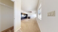 This 1-bedroom, 1-bathroom unit offers a thoughtfully designed single-floor layout that maximizes functionality within a compact footprint. The open-concept living and kitchen area serves as the heart of the unit, featuring warm neutral carpet throughout and a ceiling fan that enhances air circulation and comfort. The kitchen is well-equipped with dark espresso cabinetry extending to the ceiling for ample storage, black appliances including a refrigerator and range, a sink with surrounding countertop workspace, and a freestanding peninsula with a stone-look countertop that provides additional prep space and a natural division between the kitchen and living area. The bedroom is a comfortable, carpeted retreat filled with natural light from a window fitted with blinds. The bathroom features a full soaking tub and shower combination with clean white surrounds, accented by wood-look flooring and brushed nickel grab bars. A dedicated laundry room houses a full-sized washer and dryer, adding significant convenience. A walk-in closet with overhead rod and shelf provides practical storage. Overall, the unit presents a clean, neutral palette with consistent finishes throughout.