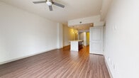 Located in the heart of uptown Charlotte, this well-appointed residence offers a thoughtfully designed open-concept floor plan with modern finishes throughout. The main living area features warm wood-tone luxury vinyl plank flooring, crisp white walls, and a ceiling fan, creating a bright and airy atmosphere. Sliding glass doors lead to a private balcony with impressive views of the Charlotte skyline, flooding the space with abundant natural light.

The kitchen is a standout feature, showcasing rich dark-wood cabinetry, a white quartz countertop island with a pendant-lit overhang, a tile backsplash, and a full suite of stainless steel appliances including a refrigerator with ice maker, range, and microwave. The island provides additional seating and prep space, seamlessly connecting the kitchen to the living area.

The bedroom is generously sized with plush carpeting, a ceiling fan, and large windows that frame city views. A walk-in closet with built-in shelving offers practical storage. The bathroom is clean and contemporary, featuring large-format tile flooring, a soaking tub with tiled surround, a dark-wood vanity, and white quartz countertops, all finished with polished chrome fixtures.
