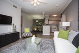 Located in Franklin, TN, this single-floor residence offers a thoughtfully designed layout with a range of functional and comfortable spaces. The kitchen is equipped with light wood cabinetry, generous counter space, wood-look plank flooring, and white appliances including a dishwasher, electric range, and refrigerator — providing everything needed for everyday cooking. The living room features crown molding, a ceiling fan, and sliding glass doors that open to an outdoor patio, allowing ample natural light and views of the surrounding greenery. A dedicated dining area with a pendant light fixture and crown molding provides a defined space for meals. Two bedrooms are present, each with ceiling fans, plush carpet, and walk-in closet access. The primary bedroom offers a serene, restful atmosphere with generous proportions. Two full bathrooms serve the residence — one with a wood-tone vanity, bright vanity lighting, and a tub/shower combination, and a second with clean white fixtures and a tub/shower combo. A dedicated laundry area houses a full-size side-by-side washer and dryer with overhead shelving. Throughout the home, neutral tones, wood-look flooring, and consistent finishes create a cohesive and inviting atmosphere.