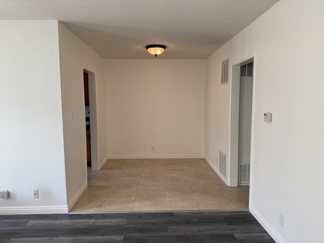 Dining area, with kitchen entrance to the left and entrance to the hallway to the right leading to b - 5462 Barton Ave