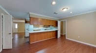 Located on Ledo Road in Albany, Georgia, this single-story home offers a functional and straightforward layout designed for comfortable everyday living. The kitchen serves as a central feature of the home, showcasing warm oak cabinetry with raised-panel detailing, white countertops, and white appliances including a range, dishwasher, and refrigerator. A peninsula with a breakfast bar extends into the adjoining living area, creating an open, connected feel between the kitchen and main living space. Crown molding and recessed lighting add a refined touch to this area, while a textured ceiling is consistent throughout the home.

Hardwood-style flooring runs through the kitchen, living areas, and secondary bedrooms, while plush carpeting covers the primary bedroom and additional carpeted rooms, providing warmth underfoot. The primary bedroom is generously sized, featuring a ceiling fan with lighting and a walk-in closet equipped with a full-length hanging rod and built-in shelving for organized storage.

The bathrooms are finished with wood-tone vanity cabinetry, white countertops, and hardwood-style flooring. The full bathroom includes a tub-shower combination, while a half bath provides added convenience. Neutral warm-toned walls are consistent throughout, giving the home a cohesive and welcoming ambiance.