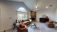 Located in Fairfield Knolls South in Coram, New York, this two-floor home showcases an thoughtfully designed layout with notable architectural details throughout. The living room serves as a central highlight, featuring dramatic vaulted ceilings, a ceiling fan, and a striking arched window that floods the space with natural light. A floor-to-ceiling stacked stone fireplace anchors the corner of the room, adding warmth and a refined focal point. Crown molding and plush carpeting carry through the main living areas, contributing to a cohesive and polished aesthetic.

The dining area offers an intimate setting with a tray ceiling and an elegant pendant light fixture. The kitchen is outfitted with white shaker cabinetry, light stone countertops, a subway tile backsplash, and stainless steel appliances, all set over light hardwood-style flooring. A dedicated laundry area with side-by-side washer and dryer units adds everyday convenience.

The bedroom features vaulted ceilings, a ceiling fan, plush carpeting, and a large window overlooking the outdoors. The bathroom includes a rich wood vanity with a dark granite countertop, a mirrored medicine cabinet, and a tub-shower combination with glass doors. The lower level presents a wide-open, unfinished space with support columns and ample room for future customization.