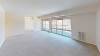 This single-floor residence offers a thoughtfully designed layout with modern finishes throughout. The renovated kitchen serves as a functional centerpiece, featuring white shaker-style cabinetry with brushed nickel hardware, granite countertops, and light wood-look flooring. A full suite of stainless steel appliances includes a gas range, dishwasher, microwave, and refrigerator. A dedicated alcove houses a stacked washer and dryer unit, providing convenient in-unit laundry.

The spacious living area is carpeted and filled with natural light from expansive sliding glass doors that open onto a private balcony with outdoor views of surrounding trees. A separate dining area with a chandelier connects seamlessly to the main living space. Ceiling fans are present in multiple rooms, contributing to comfortable air circulation throughout.

The bedrooms are carpeted and generously sized, each featuring windows that bring in natural light. One bedroom includes a closet with bifold doors, while another benefits from a ceiling fan. Two bathrooms serve the unit: one full bath with a soaking tub, shower, granite vanity, and wood-look flooring; and a second bath featuring a granite-topped double vanity and matching flooring, maintaining a consistent, clean aesthetic.