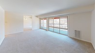 This single-floor residence offers a thoughtfully designed layout with modern finishes throughout. The renovated kitchen serves as a functional centerpiece, featuring white shaker-style cabinetry with brushed nickel hardware, granite countertops, and light wood-look flooring. A full suite of stainless steel appliances includes a gas range, dishwasher, microwave, and refrigerator. A dedicated alcove houses a stacked washer and dryer unit, providing convenient in-unit laundry.

The spacious living area is carpeted and filled with natural light from expansive sliding glass doors that open onto a private balcony with outdoor views of surrounding trees. A separate dining area with a chandelier connects seamlessly to the main living space. Ceiling fans are present in multiple rooms, contributing to comfortable air circulation throughout.

The bedrooms are carpeted and generously sized, each featuring windows that bring in natural light. One bedroom includes a closet with bifold doors, while another benefits from a ceiling fan. Two bathrooms serve the unit: one full bath with a soaking tub, shower, granite vanity, and wood-look flooring; and a second bath featuring a granite-topped double vanity and matching flooring, maintaining a consistent, clean aesthetic.
