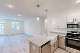 Located on Dellridge Place in Chattanooga, TN, this well-appointed 3-bedroom, 2-bathroom single-story home offers a thoughtfully designed layout with modern finishes throughout. The open-concept kitchen and living area serves as the heart of the home, featuring granite countertops, a standout farmhouse sink, a central island with pendant lighting, white upper cabinetry, warm wood-toned lower cabinets, and stainless steel appliances including a dishwasher and range. Light wood-look flooring runs through the main living areas, creating a bright and cohesive aesthetic. The spacious primary bedroom offers plush carpeting, a ceiling fan, and a window with natural light, while a well-sized walk-in closet with wire shelving provides generous storage. Additional bedrooms are carpeted and feature windows overlooking the exterior. The bathrooms include light wood-look flooring, granite-topped vanities, and a soaking tub. A dedicated laundry room houses a full-size washer and dryer. With five closets total, a utility room, and a hallway connecting all areas, this home balances practicality with clean, contemporary design in a comfortable single-floor living arrangement.