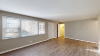 Located on W Gregory Street in Chicago's O'Hare neighborhood, this 2-bedroom, 1-bathroom unit offers a clean, modern living environment spread across a single floor. Warm-toned, hardwood-style flooring runs throughout the space, tying each room together with a cohesive aesthetic.

The main living area is generously sized, bathed in natural light through large windows fitted with blinds. Neutral gray walls complement the light floors and crisp white trim and baseboards, creating a bright and inviting atmosphere.

The kitchen is thoughtfully designed with taupe cabinetry, white subway tile backsplash, light countertops, and a full suite of stainless steel appliances including a gas range, microwave, refrigerator, and dishwasher. A ceiling fan and a window add airflow and natural light to the space.

The spacious primary bedroom features two windows, a walk-in closet, and baseboard heating. The second bedroom is equally well-finished, with hardwood-style flooring and direct access to the hallway.

The bathroom is neatly appointed with a white vanity, tiled tub-shower surround, and a privacy window. Three closets throughout the unit provide ample storage. A connecting hallway links all rooms efficiently, completing this well-organized and move-in-ready home.