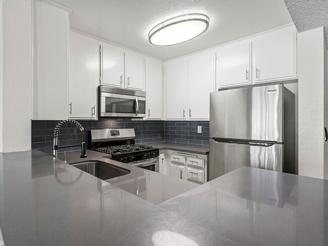 Kitchen with stainless steel oven, microwave, and fridge. - Tilden Oaks