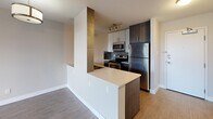 Located on the sixth floor at 335 18 Ave SW in Calgary's vibrant Mission neighbourhood, this one-bedroom, one-bathroom unit offers a thoughtfully designed open-concept layout with contemporary finishes throughout. Light-toned laminate flooring runs continuously across the living areas, creating a cohesive and clean aesthetic.

The kitchen is a standout feature, equipped with dark wood cabinetry, light quartz countertops, stainless steel appliances including a full-size refrigerator, electric range, and built-in microwave, complemented by a peninsula that defines the space and provides additional prep area. Track lighting above adds both function and style.

The open living area flows naturally from the kitchen, offering a versatile, well-proportioned space bathed in a neutral palette. The bedroom is a comfortable retreat featuring a closet with built-in wire shelving and a large window with a built-in storage cabinet beneath, framing views of the surrounding Calgary cityscape.

The bathroom is finished with a soaker tub and shower combination, tiled surround, a dark wood vanity with quartz countertop, and modern pendant lighting. In-suite laundry is tucked neatly into a dedicated closet with a stacked full-size washer and dryer, completing this efficient and well-equipped home.
