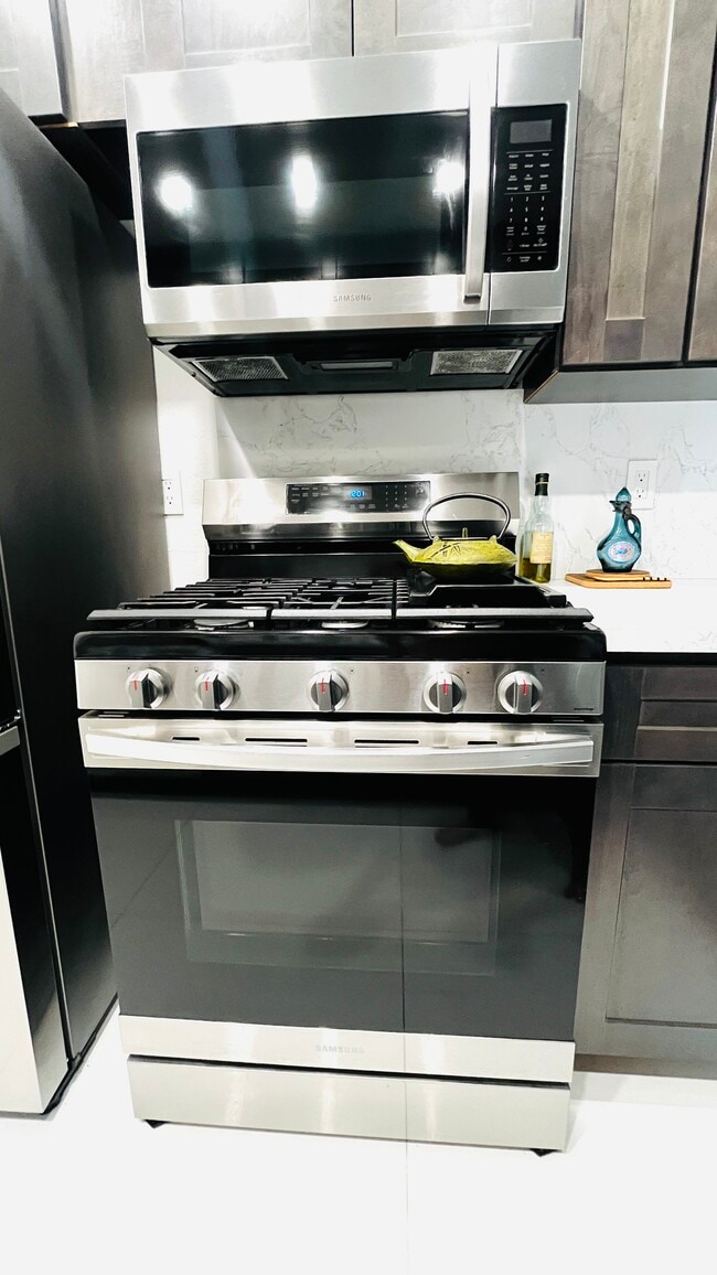 New kitchen With stainless steel refrigerator, dishwasher, microwave, and stove. Garbage disposal - 6600 Warner Ave