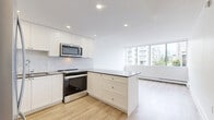 Located on the 7th floor at 1255 Pendrell St in Vancouver's desirable West End neighbourhood, this one-bedroom, one-bathroom unit offers a well-designed layout across a single floor. Light wood laminate flooring flows throughout the space, creating a bright and cohesive aesthetic.

The open-concept kitchen and living area serves as the heart of the unit. The kitchen is outfitted with white shaker-style cabinetry extending to the ceiling, stainless steel appliances including a refrigerator, range, built-in microwave, and dishwasher, complemented by dark quartz countertops and a herringbone-patterned tile backsplash. A peninsula provides additional counter space and separates the kitchen from the living area, which benefits from large windows offering views of the Vancouver cityscape.

The bedroom is a comfortable size, featuring a mirrored sliding door closet, light wood flooring, and windows that draw in natural light and frame urban views.

The bathroom is finished with classic white subway tile surrounding the bathtub and walls, a stone-topped vanity, and tile flooring, giving it a clean and timeless look.

Throughout the unit, recessed lighting, baseboard heating, and a neutral white palette contribute to a clean, modern, and functional living environment.