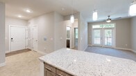 Located in Charlotte, NC, this 1-bedroom, 1-bathroom residence offers a thoughtfully designed layout with modern finishes throughout. The open-concept kitchen is a standout feature, showcasing grey shaker-style cabinetry, granite countertops, a white subway tile backsplash, and a suite of stainless steel appliances including a refrigerator, range, dishwasher, and built-in microwave. A granite-topped kitchen island provides additional prep space and is highlighted by stylish pendant lighting overhead. Wood-look plank flooring flows throughout the main living and kitchen areas, creating a cohesive and contemporary aesthetic. The living area transitions naturally from the kitchen, benefiting from abundant natural light through large windows and glass doors. The generously sized bedroom features soft carpet flooring, a ceiling fan with light, and a window with a pleasant outdoor view. An adjoining walk-in closet offers multi-tier wire shelving for ample storage. The bathroom is clean and functional, featuring a granite vanity, wood-look flooring, and a glass-door shower enclosure. A hallway connects the rooms efficiently, completing this well-organized and move-in-ready home.