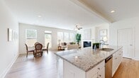 Located at 2146 Miller Chapel Rd SE in Conyers, GA, this well-appointed two-story home offers five bedrooms and three bathrooms across two generous floors. The main level welcomes you through an elegant arched hallway that flows into a bright, open-concept kitchen and living area. The kitchen is equipped with white shaker cabinetry, granite countertops, stainless steel appliances, a central island with sink, and a subway tile backsplash. The adjoining living room features a classic fireplace, ceiling fan, and an abundance of natural light streaming through multiple windows and a glass door that opens to the backyard. A dedicated dining area completes this communal space. Upstairs, the expansive primary bedroom provides a comfortable retreat with large windows and ample natural light. Four additional bedrooms feature hardwood-style flooring and bright windows with outdoor views. Three full bathrooms, including a clean tub-shower combo, serve the home with ease. A dedicated laundry room houses a full-size washer and dryer. Throughout, the home showcases a consistent palette of crisp white walls, light hardwood-style flooring, and clean architectural details, creating a cohesive and inviting atmosphere. A fenced backyard with a grassy lawn completes this functional and well-designed home.