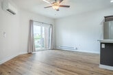 Located on Central Park Place in Fitchburg, WI, this thoughtfully designed one-bedroom, one-bathroom unit offers a modern, open-concept layout with stylish finishes throughout. The combined kitchen and living area serves as the heart of the home, anchored by a large center island with a quartz countertop, undermount sink, and pendant lighting. Rich, dark-toned cabinetry pairs beautifully with a full suite of stainless steel appliances, including a French door refrigerator, electric range, and built-in microwave. Light wood-look flooring flows throughout the main living areas, enhancing the bright, airy feel. A sliding glass door in the living area opens to a private patio, filling the space with natural light and outdoor views. The bedroom features plush carpeting, a ceiling fan, a wall-mounted climate control unit, and direct access to a generously sized walk-in closet with built-in wire shelving. The clean, well-appointed bathroom includes a soaking tub and shower combo, a dark-toned vanity with a white countertop, and coordinating wood-look flooring. Additional highlights include an in-unit laundry area, a dedicated pantry, and multiple closets offering exceptional storage throughout.