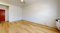 Located at 919 S Manhattan Pl in the Mid-City neighborhood of Los Angeles, CA, this efficiently designed single-floor unit offers a thoughtful layout across a cozy footprint. Light hardwood flooring runs consistently throughout the space, creating a warm and cohesive aesthetic from room to room.

The living area is bright and open, featuring white walls, a ceiling fan with light fixture, and a double window that invites natural light while offering views of the surrounding neighborhood. A wall-mounted heating unit and a window air conditioning unit ensure year-round comfort.

The kitchen is compact and functional, equipped with a white gas range with overhead ventilation hood, a tile-topped counter, and a sink — providing the essentials for everyday meal preparation in an efficient space.

The bathroom continues the light and clean aesthetic with wood-look tile flooring, a toilet, and a standalone shower enclosed by a frosted glass door with a chrome frame. A towel bar adds a practical finishing touch.

The entrance provides a clean transition into the unit, setting the tone for the simple, neutral interior throughout. The overall design palette — white walls, light floors, and chrome accents — gives the space a fresh, move-in-ready feel suitable for urban living in Los Angeles.