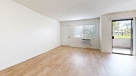 Located at 845 Paularino Ave in Costa Mesa, CA, this 2-bedroom, 1-bathroom unit offers a well-designed single-floor layout that makes efficient use of its space. The open living area features light wood-style flooring, crisp white walls, a textured ceiling, and a ceiling fan, creating a bright and airy atmosphere. A sliding glass door connects the living area to a private outdoor patio, allowing natural light to flow freely throughout.

The galley-style kitchen is thoughtfully appointed with white shaker cabinetry, dark countertops with brushed gold hardware, stainless steel appliances including a range, microwave, and refrigerator, and a deep undermount sink with track lighting above.

Both bedrooms are carpeted and include ceiling fans and windows with blinds for natural light and privacy. The primary bedroom features mirrored sliding closet doors, while the secondary bedroom offers a wall-unit air conditioner and direct access to the hallway. The shared bathroom is cleanly finished with a white vanity, dark countertop, framed mirror, and a well-lit vanity light bar. A connecting hallway with built-in cabinetry ties the layout together, providing additional storage throughout this functional Costa Mesa residence.