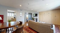 Located in Nashville's desirable 12 South neighborhood, this thoughtfully designed one-bedroom, one-bathroom residence makes excellent use of its single-floor layout. Warm hardwood floors flow throughout, unifying each room with a cohesive, inviting feel.

The living room is a standout space, anchored by a wall of built-in light wood cabinetry that conceals a Murphy bed — a clever design element offering flexibility. A wall-mounted TV, open shelving, and a bold patterned area rug add character, while a large window with navy drape panels invites natural light and outdoor views of the surrounding greenery.

The galley-style kitchen is well-appointed with granite countertops, stainless steel appliances including a gas range, white subway tile backsplash, and warm wood cabinetry. A window above the counter provides additional natural light.

The bedroom is a calm, light-filled retreat featuring recessed lighting, a wide window with outdoor views, and access to a dedicated closet. Soft grey walls and rich hardwood floors lend a serene, grounded atmosphere.

The bathroom is crisp and modern, finished with full subway tile walls, a glass-enclosed walk-in shower with mosaic tile flooring, a wood-toned vanity with a white countertop, and a window that brightens the space naturally.

A hallway and two closets round out this efficient, well-curated Nashville residence.