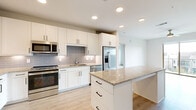 Located in Allen, TX, this thoughtfully designed one-bedroom, three-bathroom residence offers a bright and modern living experience across a single floor. The open-concept kitchen and living area serves as the heart of the home, featuring light wood-look flooring, a ceiling fan, and a sliding glass door that opens to a private balcony with neighborhood views. The kitchen is well-appointed with crisp white shaker cabinetry, a gray subway tile backsplash, granite countertops, stainless steel appliances including a range, microwave, and French door refrigerator, and a central island with additional storage — ideal for both cooking and casual dining. A pantry provides generous extra storage. The bedroom is a comfortable retreat with plush carpeting, a ceiling fan, and multiple windows that welcome natural light. It connects directly to a spacious walk-in closet outfitted with built-in shelving and hanging rods, as well as an en-suite bathroom featuring tile surround, granite vanity, and white cabinetry. Two additional bathrooms serve the rest of the home. A dedicated laundry area and five closets throughout add to the unit's practical appeal. The clean, neutral palette and contemporary finishes create a cohesive, move-in-ready atmosphere.