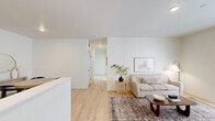 Located at 10181 Burns Rd in Pasco, WA, this well-designed 2-bedroom, 2-bathroom home offers a thoughtfully arranged single-level floor plan that maximizes every square foot. The living room features light wood flooring, neutral walls, and access to an outdoor area through a glass-panel door, allowing natural light to flow freely into the space. Adjacent to the living area, the dedicated dining space is clean and modern, with light wood flooring continuing throughout and a minimalist aesthetic accented by a wall-mounted mirror and console table. The kitchen is well-appointed with two-tone cabinetry — white uppers paired with dark wood lower cabinets — white quartz countertops, and black appliances including a refrigerator, range, and over-the-range microwave. Both bedrooms are carpeted for comfort, with the primary bedroom offering a generous layout and closet space with direct access to a dedicated bathroom. A second bedroom provides convenient access to an in-unit laundry area equipped with a full-size washer and dryer. Both bathrooms echo the home's modern design, featuring wood-toned vanities, white quartz counters, and matte black hardware accents. The overall aesthetic is clean, contemporary, and cohesive throughout.