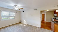 Located at 2013 Castlerea Ct in Virginia Beach, Virginia, this single-floor, 2-bedroom, 1-bathroom home offers a practical and comfortable layout. The living room is bright and inviting, featuring plush carpeting, a ceiling fan with light fixture, and a window that allows natural light to fill the space. The kitchen is well-appointed with warm honey-toned wood cabinetry reaching the ceiling, dark granite countertops, a stainless steel sink, a white electric range, and hardwood flooring — providing both style and functionality. Both bedrooms are carpeted and receive ample natural light through blinded windows, creating a calm and comfortable atmosphere. The primary bedroom is a generous size, also equipped with a ceiling fan for added comfort. A dedicated closet offers convenient storage. The bathroom includes a full-sized soaking tub and shower combination with a clean white surround and warm wood cabinetry above. Throughout the home, neutral tones, white trim, and consistent finishes create a cohesive and move-in ready feel. The single-story layout ensures easy accessibility and seamless flow between all living spaces.