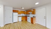 Located at 23069 Meadow Wood Ct in Seaford, Delaware, this single-floor, one-bedroom, one-bathroom home offers a well-organized layout designed for comfortable everyday living. Light hardwood-style flooring runs throughout the main living areas, creating a clean and cohesive aesthetic.

The open-concept kitchen and living room area forms the heart of the home. The kitchen features warm honey-toned wood cabinetry extending to the ceiling for ample storage, dark granite-style countertops, a full suite of white appliances including a refrigerator, dishwasher, and electric range, and recessed lighting overhead. The adjoining living area is bright and airy, highlighted by a large sliding glass door that fills the space with natural light and provides access to an outdoor area.

The bedroom is a generously sized, private retreat finished with plush neutral carpeting and a large window fitted with blinds, allowing for natural light and privacy. A dedicated closet provides convenient storage within the bedroom.

The bathroom is finished with matching wood-toned cabinetry, a white countertop vanity, and a full tub-shower combination with clean white surround panels. Light hardwood-style flooring ties the bathroom's design together with the rest of the home. Clean white walls and consistent finishes throughout give this home a fresh, move-in-ready feel.