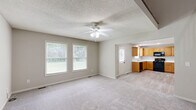 Located at 1000 Wildcat Run in Gardner, Kansas, this three-bedroom, four-bathroom home spans three floors and offers a practical, well-organized layout. The main level features a kitchen with warm oak cabinetry, black appliances, a double sink, and light wood-look vinyl flooring. A pantry provides additional storage. The living area on this floor is finished with plush carpet, a ceiling fan with light fixture, and a staircase with wood-toned railings that connects the levels seamlessly. Each of the three bedrooms is carpeted and features neutral tones, ceiling fans, and ample closet space. The primary bedroom includes a private en-suite bathroom with a walk-in shower enclosed by sliding glass doors and wood-finish vanity cabinetry. Additional bathrooms throughout the home are clean and functional, featuring single-sink vanities with white countertops and mirrored accents. The attached garage provides convenient enclosed parking with a standard overhead door system. The unfinished basement, with its concrete walls, exposed wood-beam ceiling, and small window, offers significant potential for customization. This home presents a straightforward and functional layout suited for a variety of living needs.