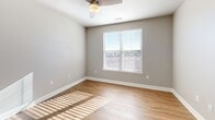 Located in Colorado Springs, CO, this well-appointed 2-bedroom, 2-bathroom residence offers a thoughtfully designed single-floor layout with a comfortable sense of space throughout. The open-concept living and dining area flows seamlessly into a modern kitchen equipped with rich dark-wood cabinetry, granite countertops, a tile backsplash, stainless steel appliances, and a central island with pendant lighting overhead — ideal for both everyday living and entertaining. Warm hardwood-style flooring runs through the main living areas, while plush carpeting adds comfort to both bedrooms. Each bedroom features a ceiling fan, natural light from windows with blinds, and generous closet space. The primary bedroom includes an en-suite bathroom with a sliding glass-door shower, built-in shelving, and granite vanity. The second bathroom echoes the same refined finishes with a dark-wood vanity and granite countertop. A dedicated in-unit laundry room houses a full-size washer and dryer with overhead shelving. Additional highlights include a private balcony, a welcoming entrance, and a hallway connecting the well-organized layout. Neutral tones and clean architectural details, including arched doorway accents, give the space a cohesive and modern aesthetic throughout.