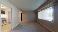 This single-floor residence at Columbus Park in Bedford Heights, Ohio offers a straightforward, functional layout across several well-defined rooms. The living area is generously sized, featuring neutral-toned carpet, a textured ceiling, and a large window fitted with vertical blinds that admits a substantial amount of natural light. A structural beam detail runs along the ceiling, adding a subtle architectural element to the space.

The kitchen is equipped with dark-stained oak cabinetry providing ample upper and lower storage, light countertops, a stainless steel sink, a gas range, and a dishwasher. Tile flooring completes the kitchen area, which opens conveniently toward the carpeted living and dining spaces.

The bedrooms are carpeted and well-proportioned, each featuring windows with blinds for natural light and privacy, along with individual closets offering organized storage. One bedroom provides direct access to a full bathroom, which includes a tiled tub-shower combination, a vanity with a mirrored medicine cabinet, and mosaic tile flooring. A second bathroom mirrors this design with matching white tile walls, a vanity, and similar mosaic flooring.

Throughout the unit, neutral wall tones and consistent finishes create a cohesive, understated ambiance.