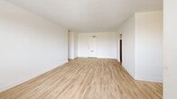 Located at 19 Rosemount Dr in Toronto's Scarborough area, this well-appointed 2-bedroom, 1-bathroom unit offers a clean, modern aesthetic throughout its single-floor layout. Light-toned vinyl plank flooring flows seamlessly through every room, creating a bright and cohesive feel.

The spacious living room is a standout feature, bathed in natural light from multiple windows that frame views of surrounding greenery. Baseboard heating units run beneath the windows, ensuring year-round comfort. The open entry area provides a welcoming foyer with direct access to the living space.

The kitchen is thoughtfully updated with crisp white cabinetry, dark countertops, a classic white subway tile backsplash, and a full suite of stainless steel appliances including a refrigerator, electric range, and over-the-range microwave. The layout connects efficiently to the rest of the unit.

Both bedrooms are generously sized, featuring large closets with sliding doors, ample wall space, and windows that let in natural light. The primary bedroom offers a comfortable footprint well-suited for a full furniture arrangement.

The bathroom is finished with large-format floor tiles, a subway-tiled tub and shower surround, a modern vanity with a white countertop, and chrome fixtures — delivering a clean, contemporary look. The unit's consistent white palette and updated finishes create a bright, move-in-ready living environment.
